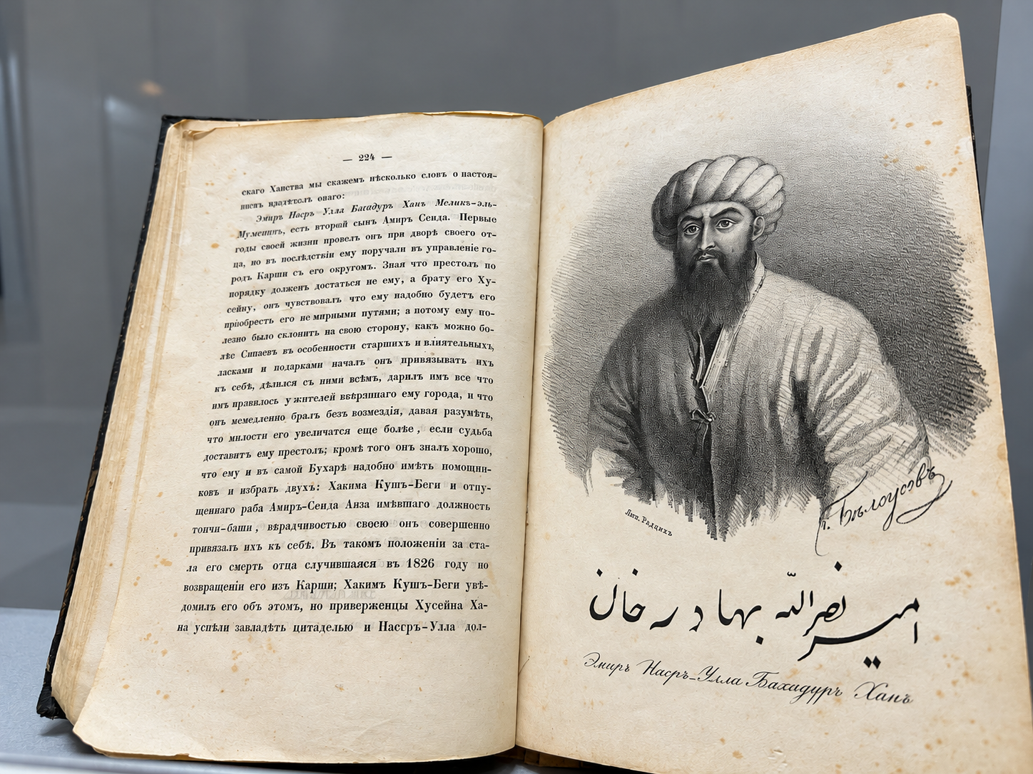 An open historical book showing a portrait of a ruler in the Ark of Bukhara museum